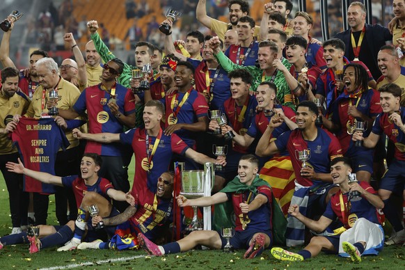 Barcelona players celebrate with the trophy after winning the Spanish Copa del Rey final soccer match between Barcelona and Real Madrid at Estadio de La Cartuja stadium in Seville, Spain, Sunday, Apri ...
