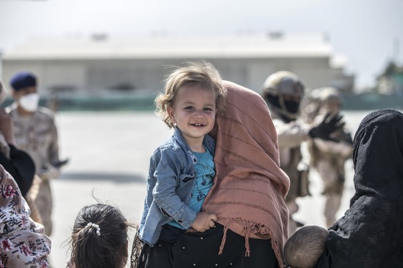 In this Aug. 21, 2021, photo provided by the U.S. Marine Corps, a child smiles as she awaits to board her flight during an evacuation at Hamid Karzai International Airport in Kabul, Afghanistan. (Sgt. ...