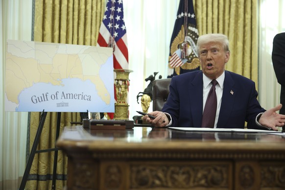 epa11894013 US President Donald Trump sits in the Oval Office near a map reading &#039;Gulf of America&#039; after signing an executive order at the White House, in Washington, DC, USA, 13 February 20 ...