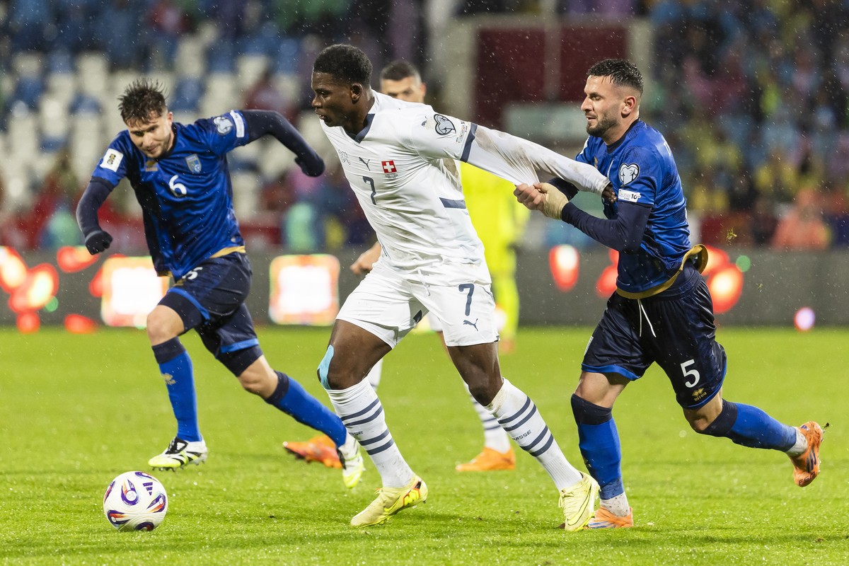 epa12534416 Switzerland's Breel Embolo, center, fights for the ball with Kosovo's Elvis Rexhbecaj, left and Kosovo's Lumbardh Dellova, right, during the FIFA 2026 World Cup Group B qual ...