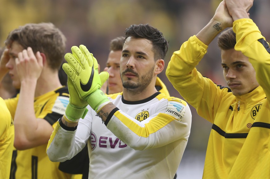 FILE - In this April 15, 2017 photo Dortmund&#039;s goalkeeper Roman Buerki und Raphael Guerreiro, right, cheer towards their fans after the German Bundesliga soccer match between Borussia Dortmund an ...