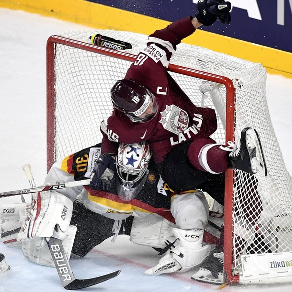 epa05968495 Latvia&#039;s forward Kaspars Daugavins (R) clashes with Germany&#039;s goalie Philipp Grubauer (L) during the 2017 IIHF Ice Hockey World Championship group A preliminary round match betwe ...