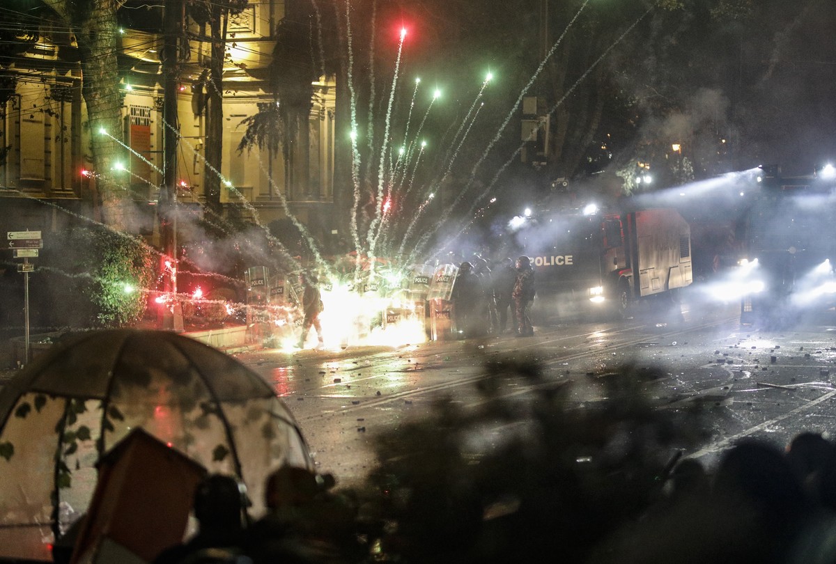 epa11748614 Georgian opposition supporters launch fireworks towards the police during a protest in front of the Parliament building in Tbilisi, Georgia, 30 November 2024. Georgian Prime Minister Kobak ...
