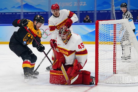 China goalkeeper Jieruimi Shimisi (Jeremy Smith) (45) stops a shot as Germany&#039;s Patrick Hager (50) watches for the rebound during a preliminary round men&#039;s hockey game at the 2022 Winter Oly ...