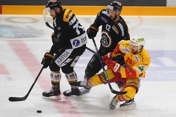 LuganoÃs player Matteo Romanenghi and LuganoÃs player Luca Cunti, left, fight for the puck with Bienne&#039;s player Dominik Diem, right, during the fourth match of the semifinal of National League  ...