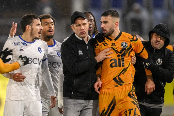 L?entraineur luganais Mattia Croci-Tortile, centre, s&#039;interpose entre le milieu lausannois Olivier Custodio, gauche, et le defenseur luganais Kreshnik Hajrizi, droite, lors de la rencontre de foo ...