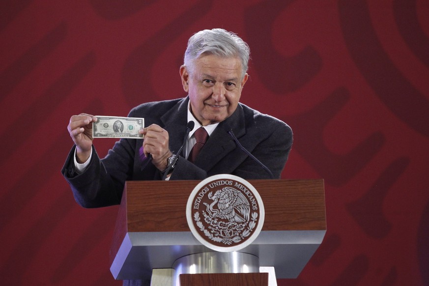 epa07262135 Mexican President Andres Manuel Lopez Obrador holds a US two-dollar note as he speaks during a press conference in Mexico City, Mexico, 04 January 2019. The Bank of Mexico promoted a const ...