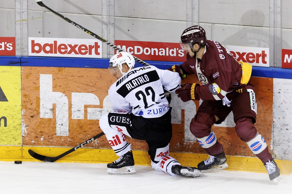 Lugano's defender Santeri Alatalo, left, vies for the puck with Geneve-Servette's forward Marco Miranda, right, during a National League regular season game of the Swiss Championship between ...