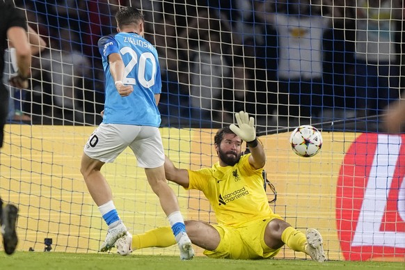 Napoli's Piotr Zielinski, left, scores his side's fourth goal past Liverpool's goalkeeper Alisson during the group A Champions League soccer match between Napoli and Liverpool at the Diego Armando Mar ...