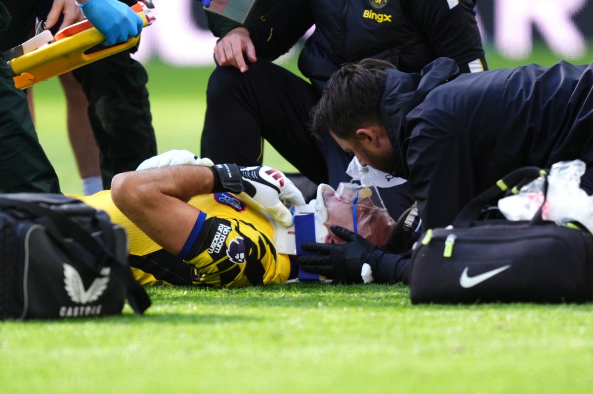 Chelsea goalkeeper Emiliano Martinez receives treatment for an injury during the English Premier League soccer match between Everton and Chelsea in Liverpool, England, Saturday, Oct. 17, 2026. (Mike E ...