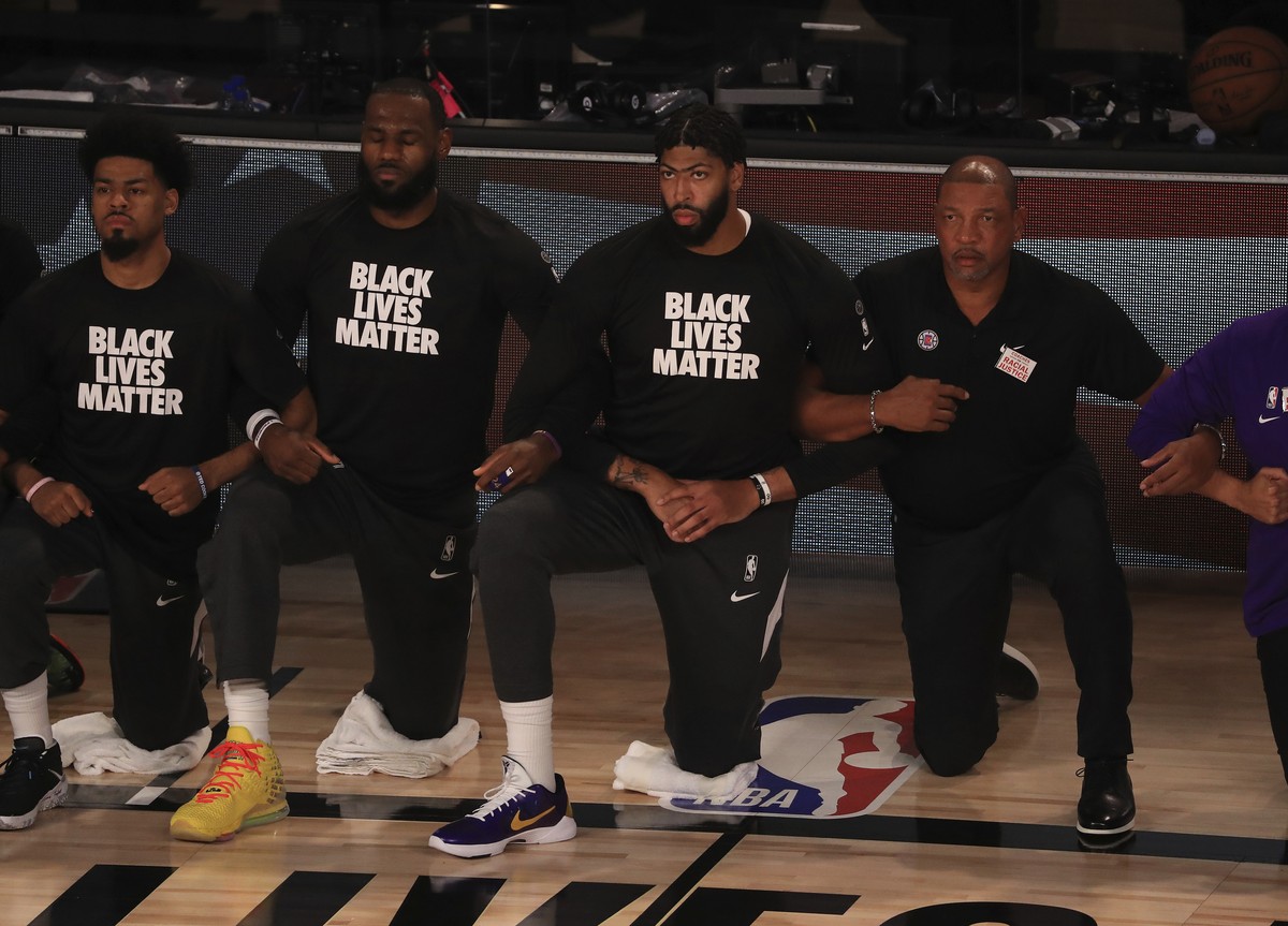 Los Angeles Lakers' LeBron James, second from left, wears a Black Lives Matter shirt and kneels with teammates during the national anthem prior to an NBA basketball game against the Los Angeles C ...