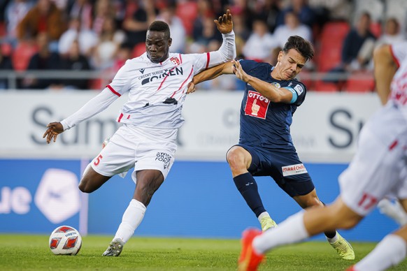 L&#039;attaquant valaisan Mario Balotelli, gauche, lutte pour le ballon avec le milieu lucernois Ardon Jashari, droite, avant de marquer lors de la rencontre du championnat de football de Super League ...