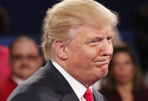 Republican U.S. presidential nominee Donald Trump reacts as Democratic nominee Hillary Clinton responds to a question about Trump&#039;s remarks about women during their presidential town hall debate  ...