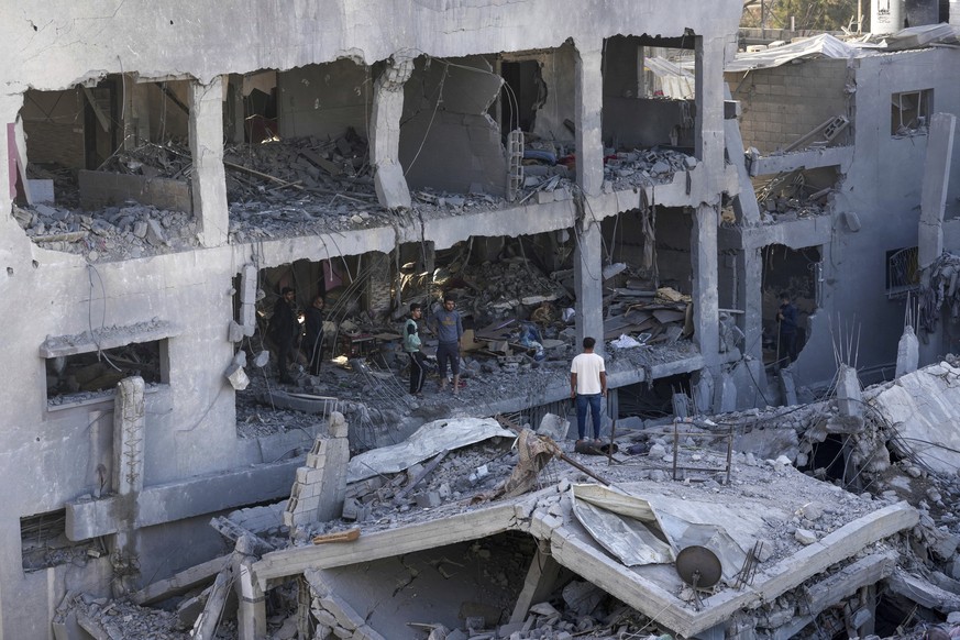 Palestinians inspect the rubble of the destroyed building of the Muharib family killed in the Israeli bombardment of the Gaza Strip in the Nusseirat refugee camp, central Gaza Strip, Thursday, November 23, 2023. (AP…