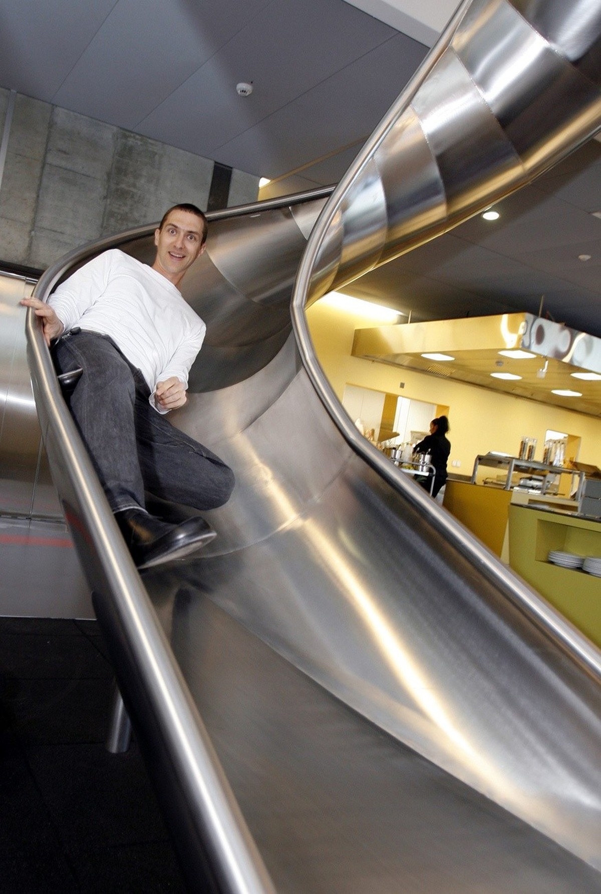 An employee of Google uses the slide to get to the canteen on the official opening day of the new Google Engeneering center in Zurich, Switzerland, Thursday, March 6, 2008. (KEYSTONE/Walter Bieri)

Ei ...