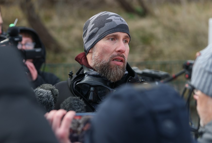 epa12850375 Marine biologist Robert Marc Lehmann talks to the media near a beached whale lying in the waters of the Baltic Sea near Niendorf harbor in Timmendorfer Strand, Germany, 26 March 2026. The  ...
