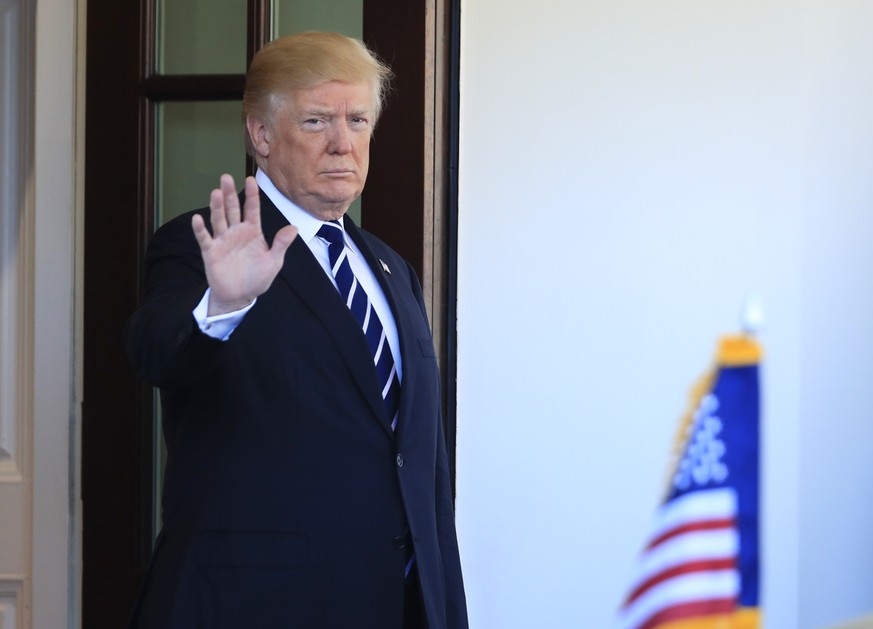 President Donald Trump waves as the vehicle carrying visiting Libyan Prime Minister Fayez al-Sarraj, arrives outside the West Wing at the White House in Washington, Friday, Dec. 1, 2017. (AP Photo/Man ...