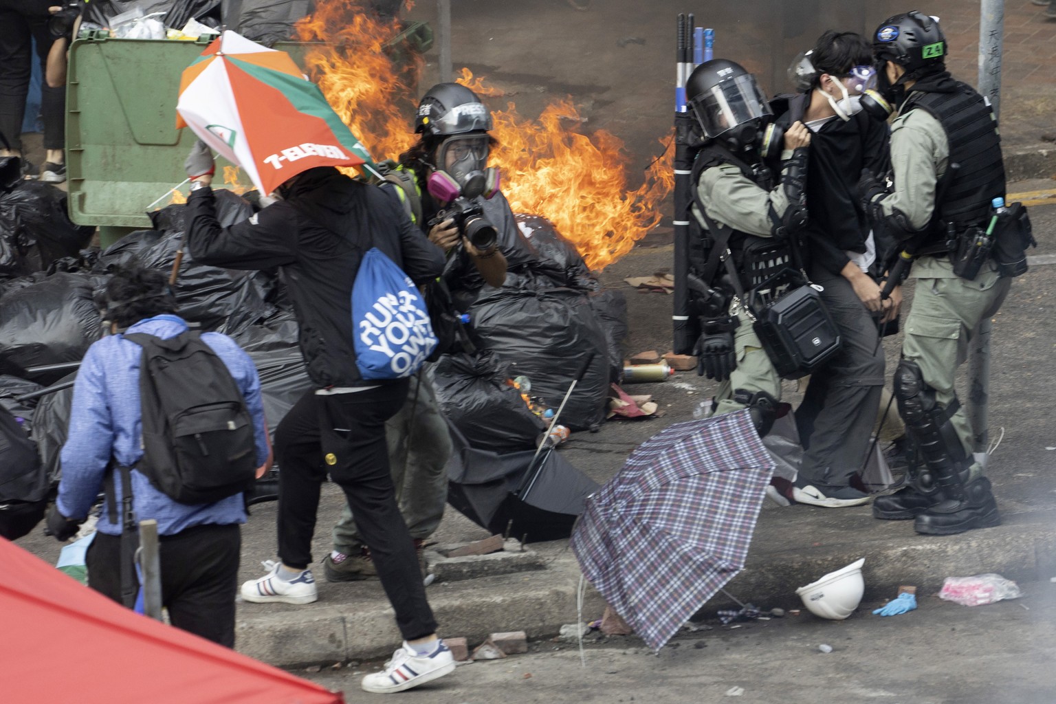 Riot police detain a protester at the Hong Kong Polytechnic University in Hong Kong, Monday, Nov. 18, 2019. Hong Kong police fought off protesters with tear gas and batons Monday as they tried to brea ...