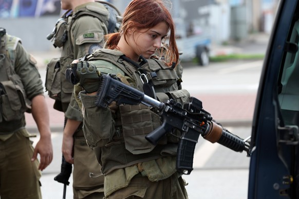epa10928953 An Israeli soldier holds her weapon ahead of a patrol, in Kiryat Shmona, northern Israel, 20 October 2023. The Israeli Defense Forces (IDF) and Ministry of Defense on 20 October, announced ...