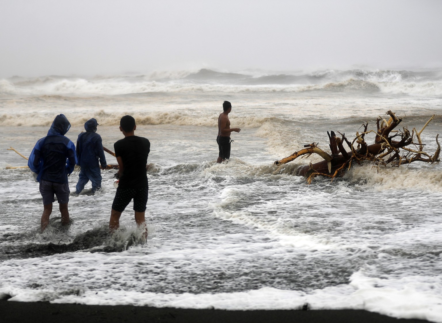 epa07021364 Filipinos frolic on waves in the typhoon-hit town of Aparri, Cagayan province, Philippines, 15 September 2018. Mangkhut, the most powerful typhoon to strike the Philippines in the last fiv ...
