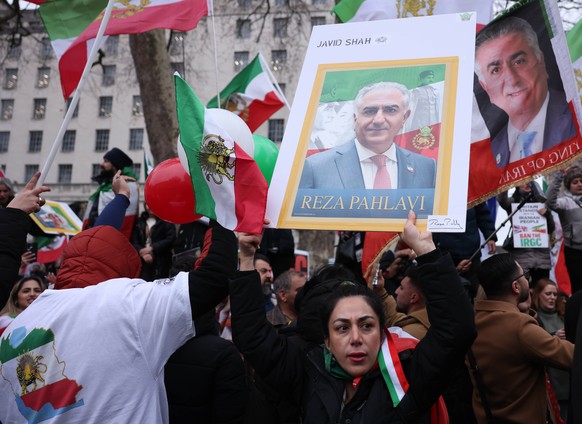epa12642924 Protesters wave pre-revolution Iranian flags and portraits of exiled Crown Prince of Iran, Reza Pahlavi, as they take part in a rally in support of current protest movement in Iran outside ...