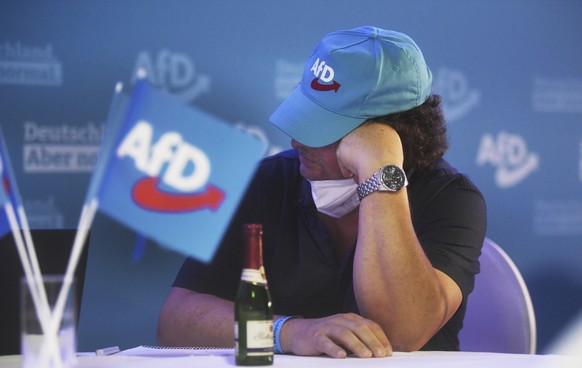 A member of the AfD sits at the AfD election party in Berlin, Sunday, Sept. 26, 2021. Exit polls show the center-left Social Democrats in a very close race with outgoing Chancellor Angela MerkelÄôs b ...