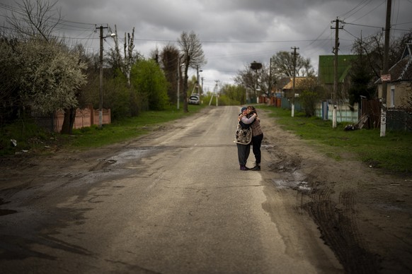 Tetyana Boikiv, 52, right, meets and hugs her neighbour Svitlana Pryimachenko, 48, during a funeral service for her husband, Mykola Moroz, 47, at the Ozera village, near Bucha, Ukraine on Tuesday, April 26, 2022. Mykola was captured by Russian army from his house in the Ozera village on March 13, taken for several weeks in an unknown location and finally found killed with gunshots about 15 kilometres from his house. (AP Photo/Emilio Morenatti)