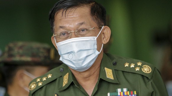 epa08978841 (FILE) - Myanmar military commander-in-chief Senior General Min Aung Hlaing (C), wearing a protective face mask, leaves after delivering a speech during a donation ceremony by Myanmar mili ...