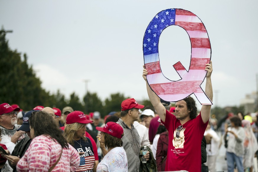 FILE - In this Aug. 2, 2018, file photo, a protester holds a Q sign as he waits in line with others to enter a campaign rally with President Donald Trump in Wilkes-Barre, Pa. Casino giant Caesars Ente ...