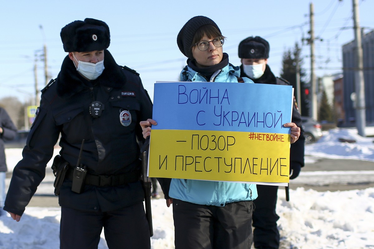 Police detain a demonstrator with a poster which reads "The war with Ukraine is a shame and a crime" during an action against Russia's attack on Ukraine in Omsk, Russia, Sunday, Feb. 27 ...