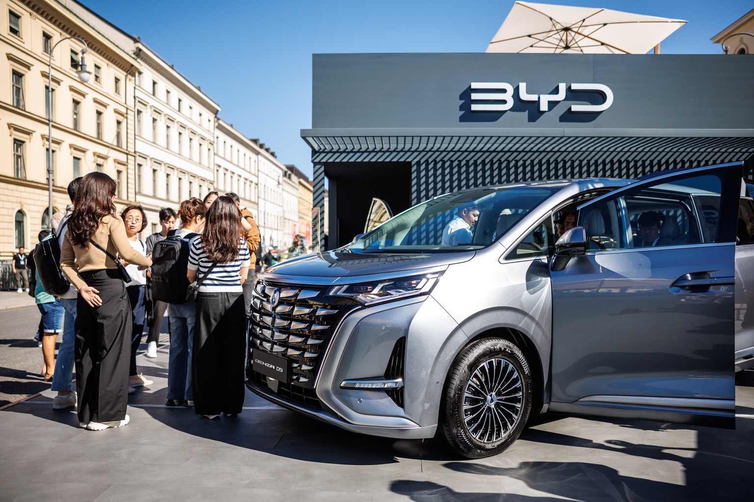 05.09.2023, Bayern, M�nchen: Standbesucher betrachten einen Denza D9 am Stand des chinesischen Herstellers BYD auf dem sogenannten Open Space der Automesse IAA 2023 in der Stadt. Die Internationale Au ...