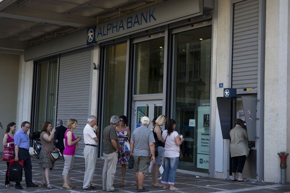 People line up to use an ATM machine outside a bank in Athens, on Monday, July 6, 2015. GreeceÂs Finance Minister Yanis Varoufakis has resigned following SundayÂs referendum in which the majority of ...