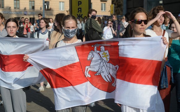 epa08699410 Participants of women&#039;s peaceful solidarity action stand with flags in Minsk, Belarus, 26 September 2020. Opposition activists continue their every day protest actions, demanding new  ...