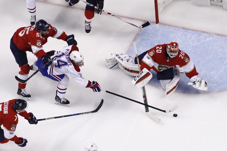 Florida Panthers goaltender Reto Berra (20) stops a shot by Montreal Canadiens center Tomas Plekanec (14) as he is checked by Florida Panthers defenseman Jason Demers (55) during the first period of a ...