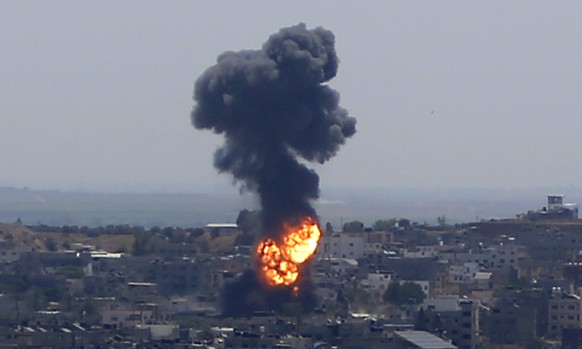 Smoke rises following Israeli airstrikes on a building in Gaza City, Thursday, May 13, 2021. Weary Palestinians are somberly marking the end of the Muslim holy month of Ramadan, as Hamas and Israel tr ...