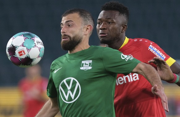 Wolfsburg&#039;s Admir Mehmedi, left, and Leverkusen&#039;s Edmond Tapsoba battle for the ball during the German Bundesliga soccer match between Wolfsburg and Bayer Leverkusen in the Volkswagen Arena, ...