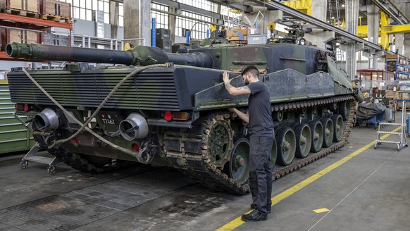 Ein Mechaniker wartet die Raupen an einem Panzer vom Typ Leopard 2 in einer Wartungshalle der RUAG, am Montag, 20. Maerz 2023, in Thun. (KEYSTONE/Peter Schneider)