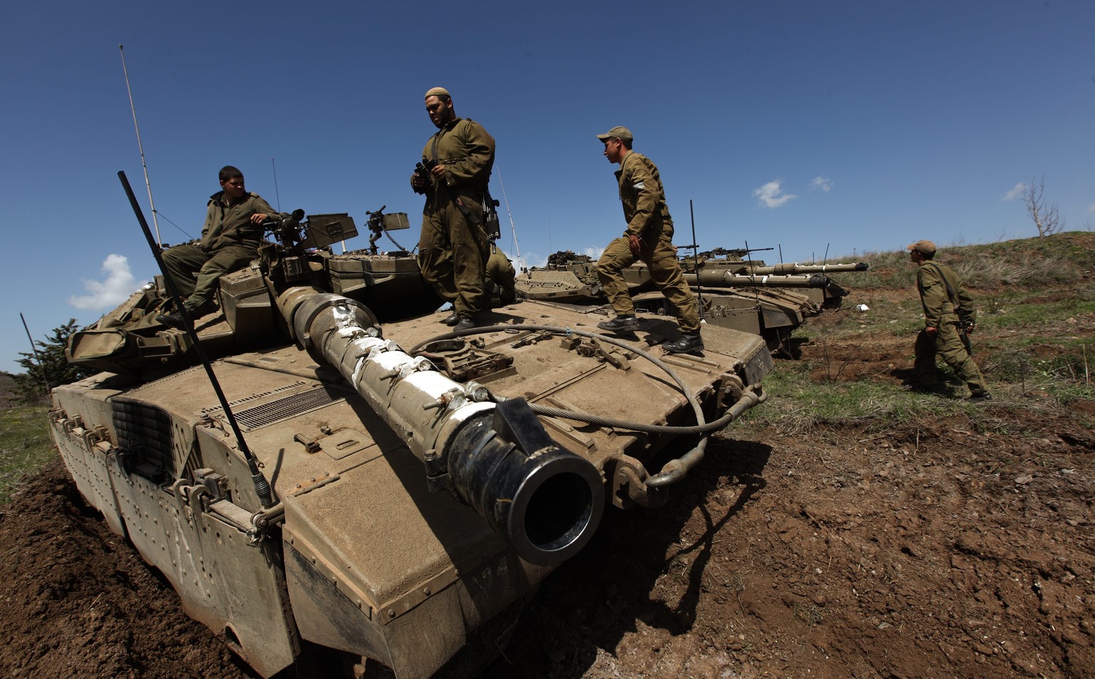 epa04133304 Israeli soldiers on their Merkava tanks deployed next to the Syrian border near the Druze border village of Majdal Shams in the Golan Heights, 20 March 2014. The Israeli army reports the i ...
