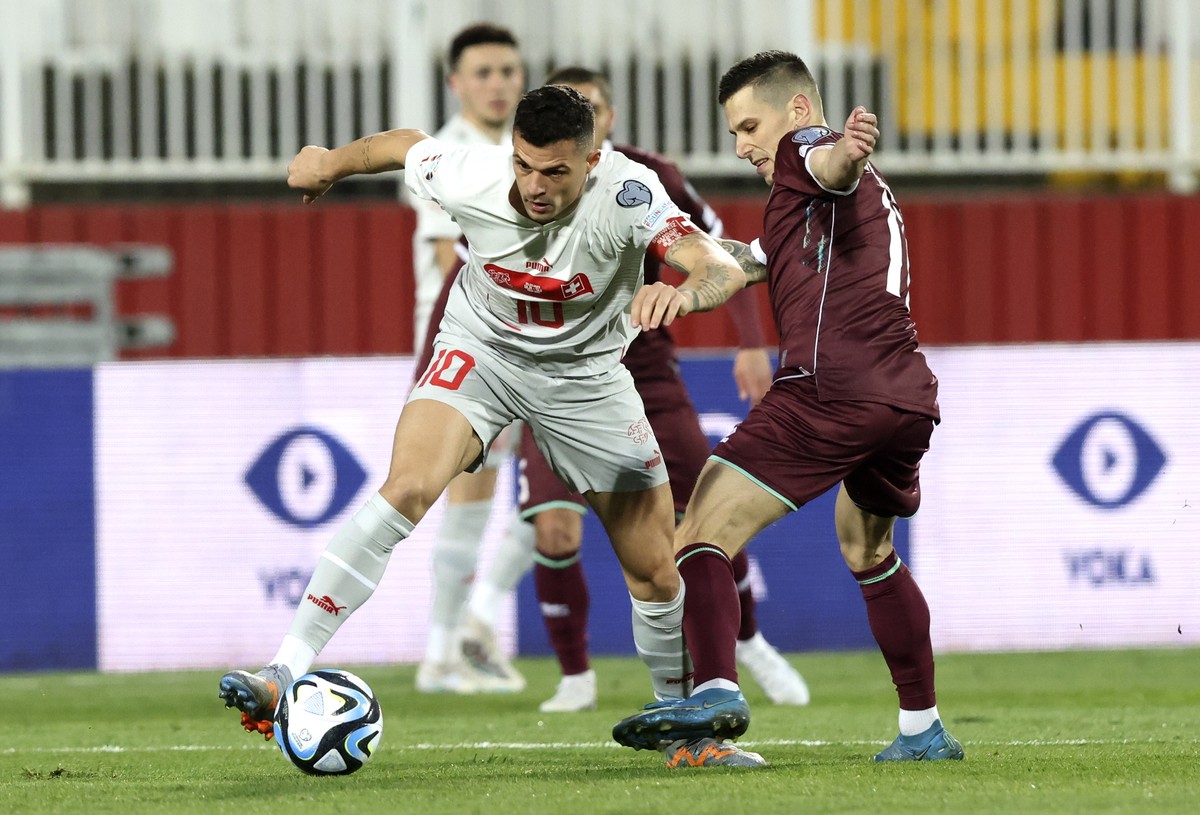epa10543021 Switzerland's Granit Xhaka (L) in action against Belarus' Vladimir Khvaschinski (R) during the UEFA EURO 2024 qualification match between Belarus and Switzerland in Novi Sad, Ser ...