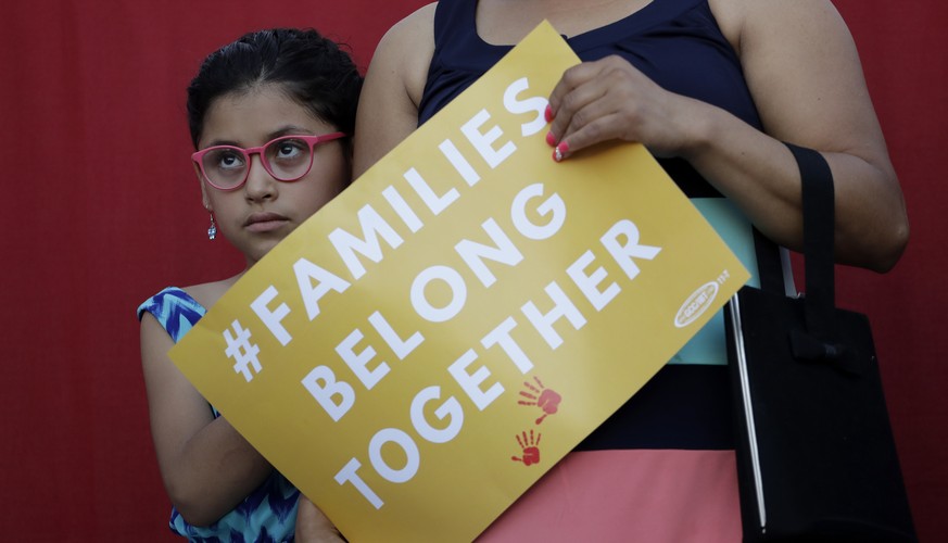 A girl stands with her mother during a Rally For Our Children event to protest a new &quot;zero-tolerance&quot; immigration policy that has led to the separation of families, Thursday, May 31, 2018, i ...