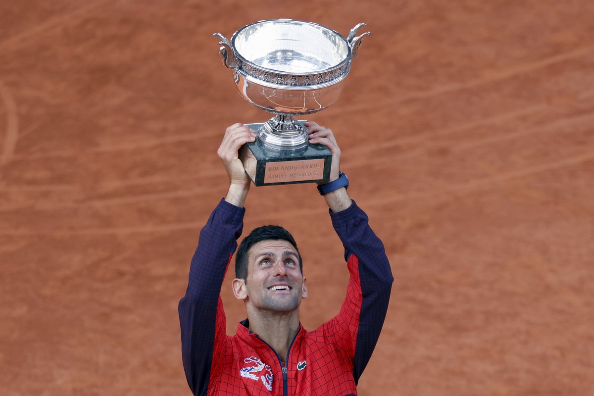Serbia's Novak Djokovic holds the trophy as he celebrates winning the men's singles final match of the French Open tennis tournament against Norway's Casper Ruud in three sets, 7-6, (7- ...