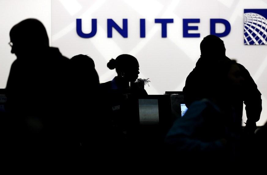 FILE - In this Saturday, Dec. 21, 2013, file photo, travelers check in at the United Airlines ticket counter at Terminal 1 in O&#039;Hare International Airport in Chicago. After a man is dragged off a ...