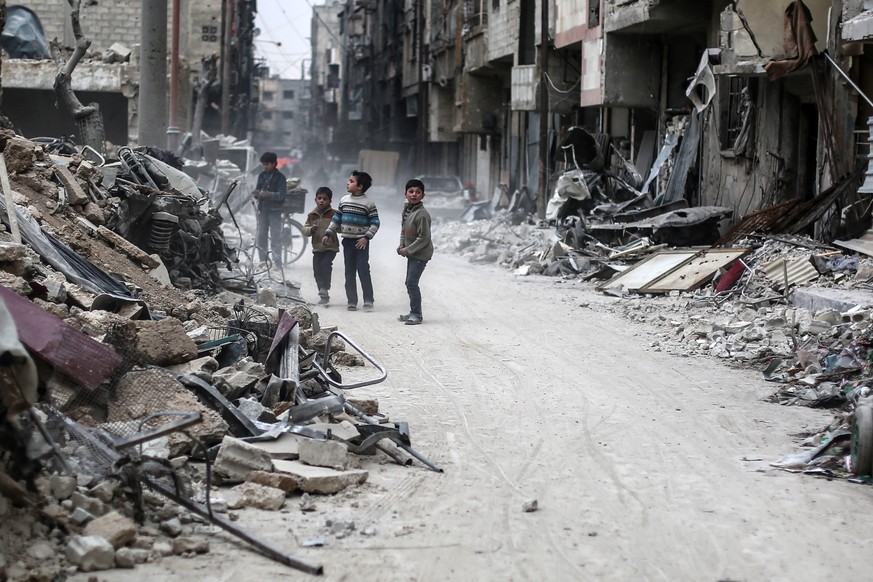 epa05821189 Children stand between the rubble, rebel-held Douma, Syria, 28 February 2017. The rubble are for buildings hit by airstrikes on 25 February 2017. EPA/MOHAMMED BADRA