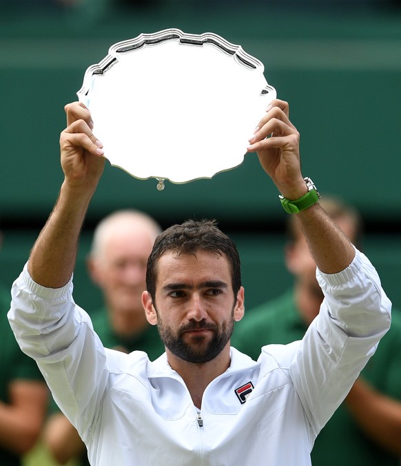 epa06091245 Marin Cilic of Croatia poses with the runner up trophy after losing against Roger Federer of Switzerland during the Men&#039;s final match for the Wimbledon Championships at the All Englan ...