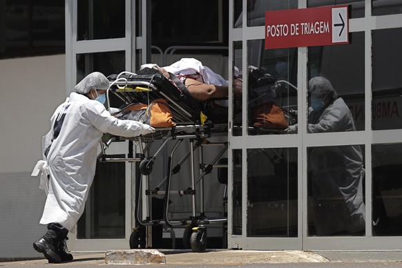 Health workers push a patient suspected of having COVID-19 into the HRAN Hospital in Brasilia, Brazil, Thursday, Jan. 7, 2021. (AP Photo/Eraldo Peres)