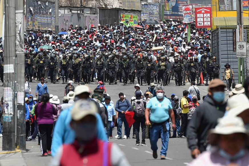 epa10365706 Police officers watch over a demonstration by supporters of deposed President Pedro Castillo, in Arequipa, Peru, 14 December 2022. The Peruvian Government declared on 14 December a state o ...
