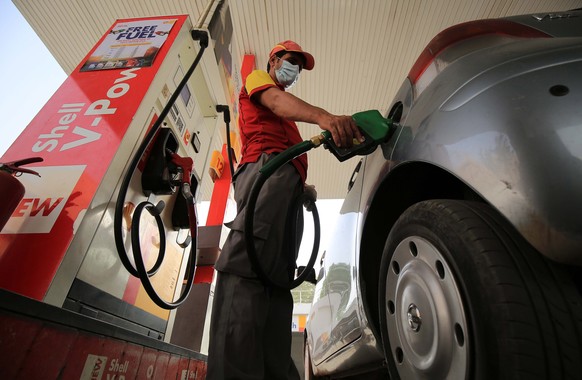 epa09276075 A gas station attendant fills a car in Peshawar, Pakistan, 16 June 2021. The Pakistani government on 16 June increased fuel prices, raising the petrol price to Rs 111.22 (0.71 US dollar) p ...