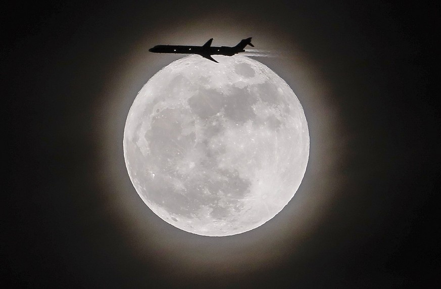 epa06365946 An airplane crosses in front of the moon, a so-called supermoon, in Avondale Estates, Georgia, USA, 03 December 2017. According to the National Aeronautics and Space Administration (NASA)  ...