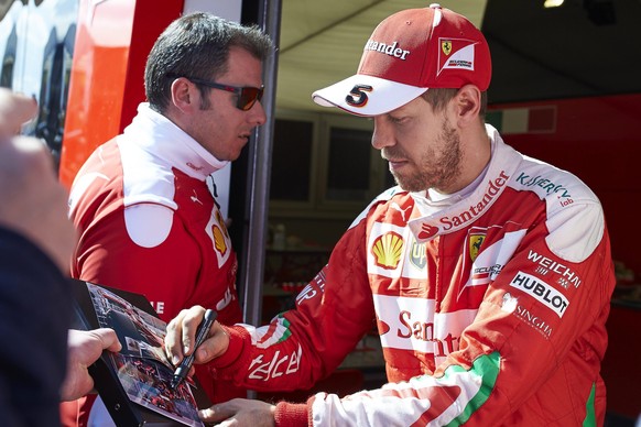 epa05194569 German Formula One driver Sebastian Vettel (R) of Scuderia Ferrari signs autographs before the 2016 pre-season testings at Circuit de Barcelona-Catalunya in Montmelo, near Barcelona, north ...