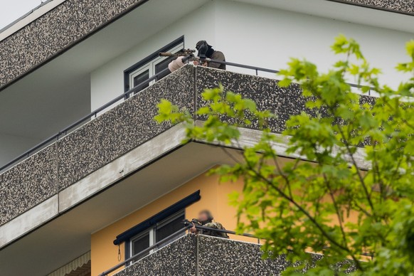 11.05.2023, Nordrhein-Westfalen, Ratingen: Ein Scharfsch�tzen (oben) und ein weiterer Beamter der Polizei sind auf einem Hochhaus mit ihren Waffen in Stellung gegangen. Bei einer Explosion in einem Ho ...